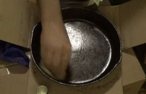 Rubbing restored cast iron frying pan with oil